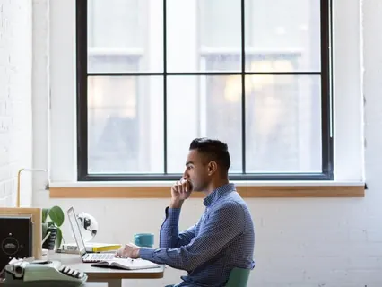 Homem com notebook e computador no escritório