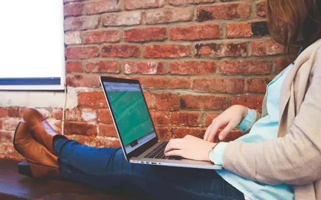 Mulher com notebook e computador no escritório